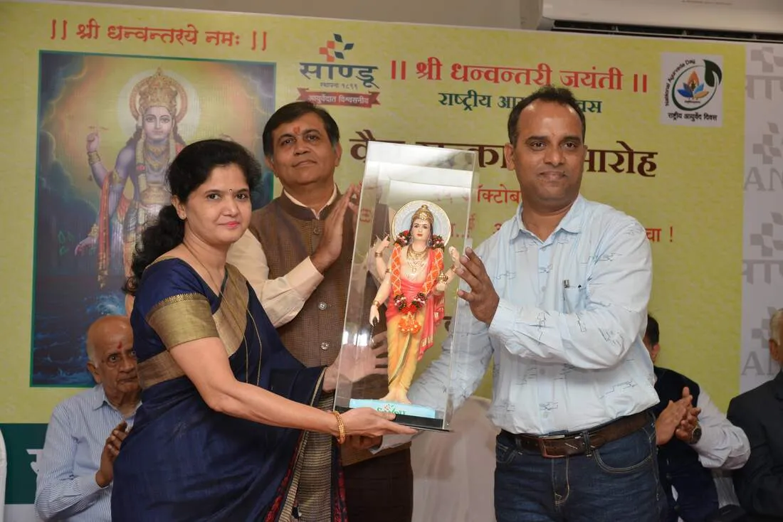 Dr. Nileema Shisode being presented with the Sandu Dhanvantari Puraskar on stage